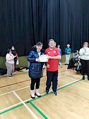 Ali receiving certificate and medal from Ellie