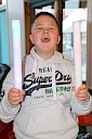 A child smiling with two coloured lights in his hands