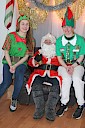 Santa sitting in his seat with two elves