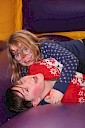 Two children hugging on the floor of the bouncy castle