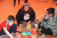 Three people playing with toys on the ground
